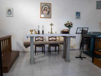 Al suo interno vediamo un altare, i banchi disposti sui lati...